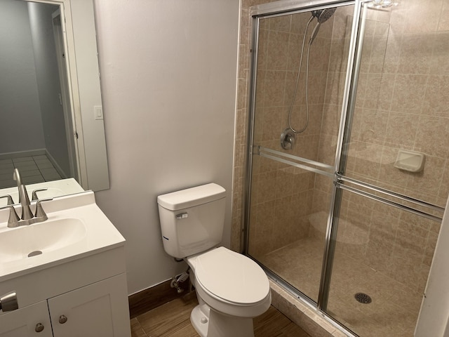 bathroom with vanity, a shower with shower door, toilet, and hardwood / wood-style flooring