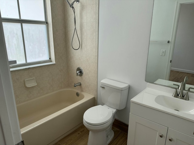 full bathroom featuring a healthy amount of sunlight, vanity, toilet, and tiled shower / bath