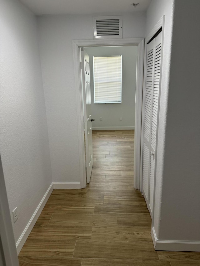 hallway with light hardwood / wood-style floors