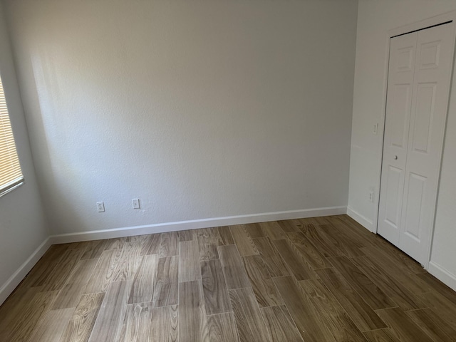 unfurnished bedroom featuring a closet and hardwood / wood-style floors