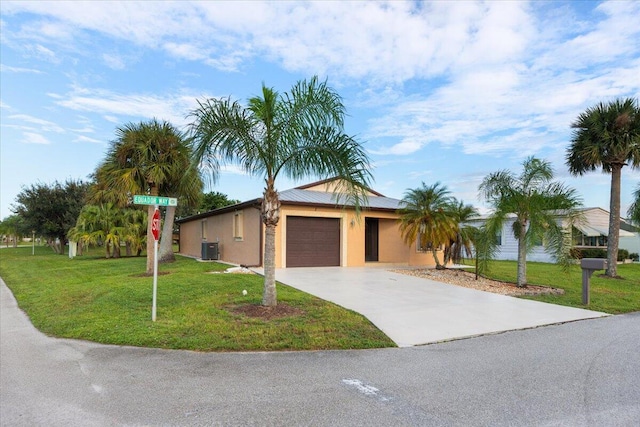 view of front of property featuring a front lawn, central air condition unit, and a garage