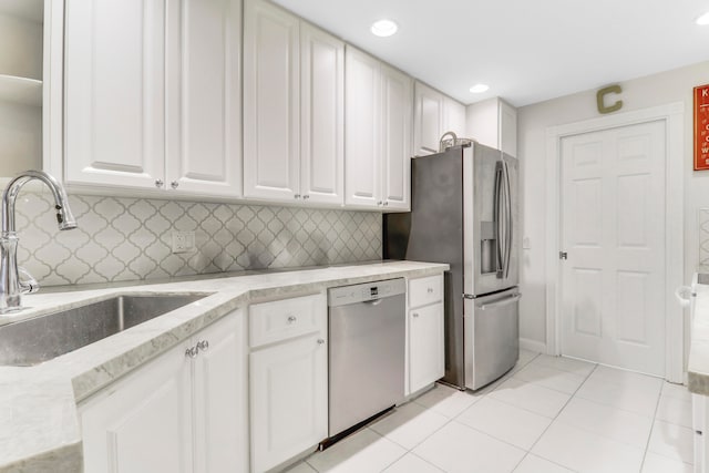 kitchen featuring white cabinets, light tile patterned flooring, sink, backsplash, and stainless steel appliances