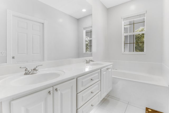 bathroom featuring tile patterned flooring, a washtub, and vanity