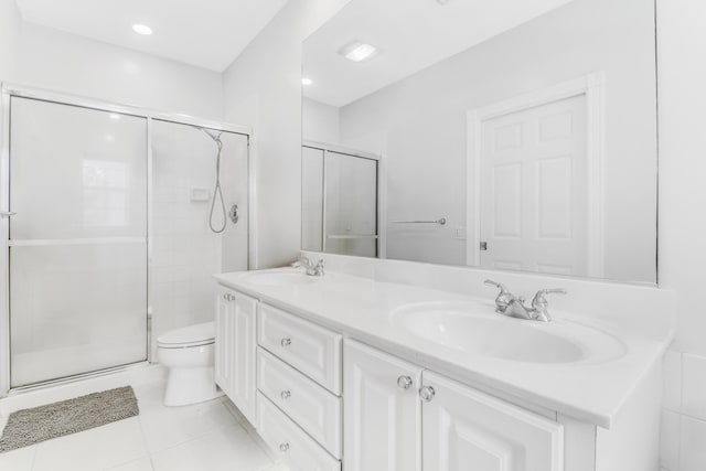 bathroom with vanity, toilet, tile patterned floors, and a shower with shower door