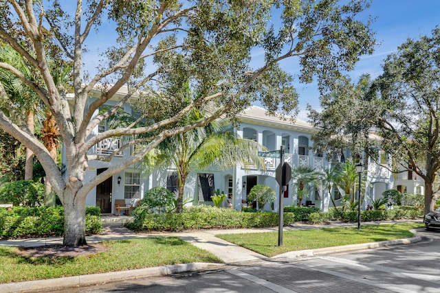 view of front of property with a balcony and a front lawn