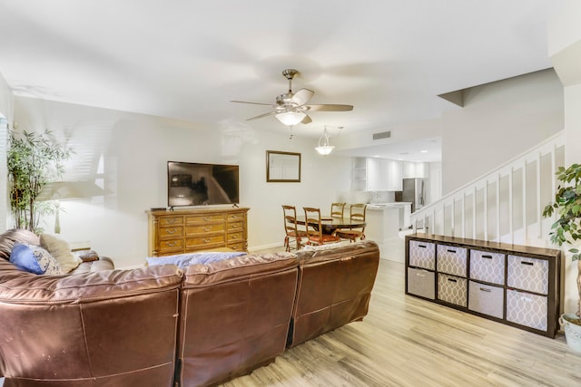 living room featuring ceiling fan and light hardwood / wood-style flooring