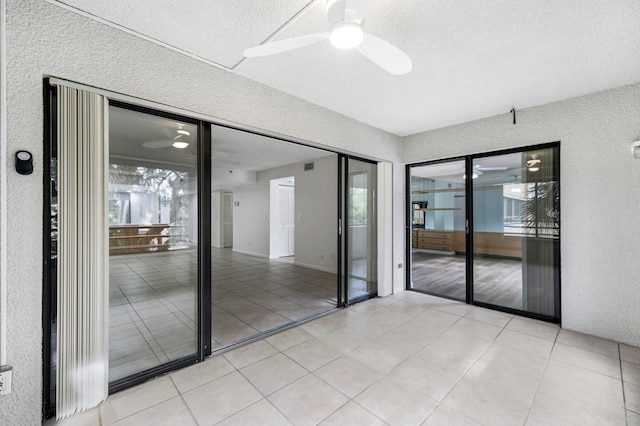 unfurnished room featuring ceiling fan, a textured ceiling, and light tile patterned floors