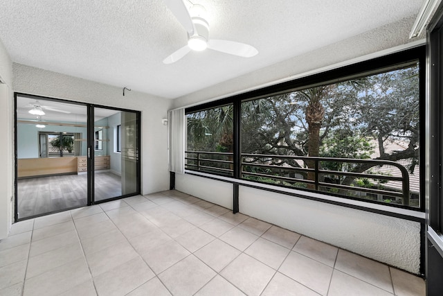 unfurnished sunroom featuring ceiling fan and a healthy amount of sunlight