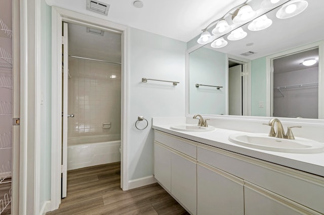 bathroom featuring hardwood / wood-style floors, vanity, and tiled shower / bath combo