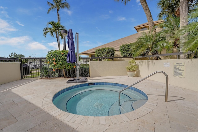 view of swimming pool with a hot tub and a patio