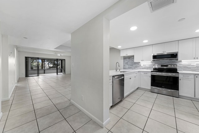 kitchen with white cabinetry, appliances with stainless steel finishes, sink, and light tile patterned floors