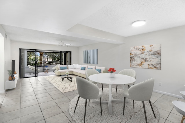 tiled dining room with a textured ceiling and ceiling fan