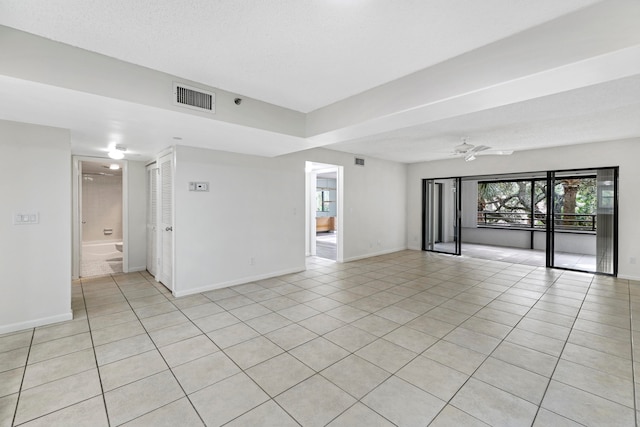 tiled empty room with a textured ceiling and ceiling fan