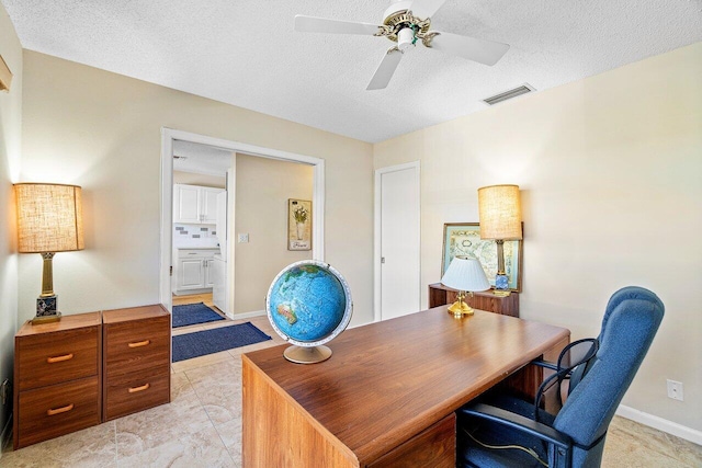 home office with a textured ceiling and ceiling fan