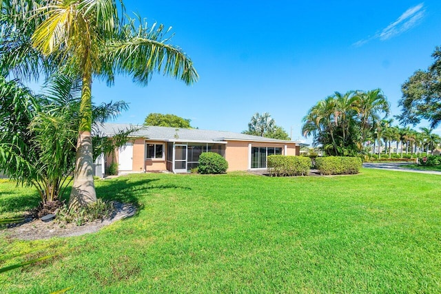 rear view of property with a sunroom and a yard