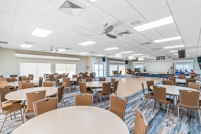 dining space with a drop ceiling and ceiling fan