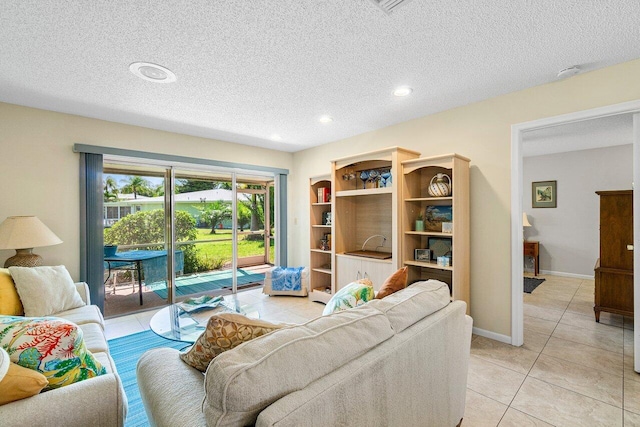 living room featuring a textured ceiling and light tile patterned floors