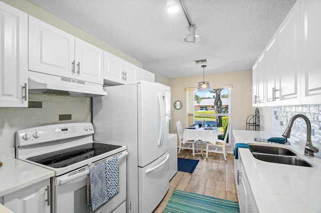 kitchen with light hardwood / wood-style floors, sink, white cabinets, white appliances, and decorative light fixtures