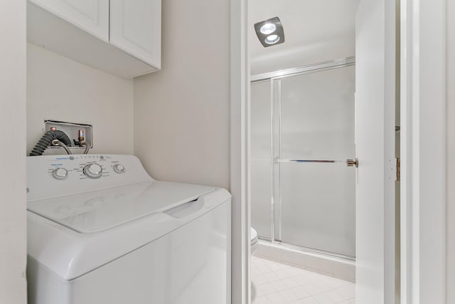 laundry area with cabinets, washer / dryer, and light tile patterned flooring