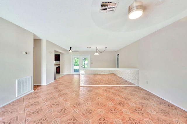 tiled empty room featuring french doors and ceiling fan