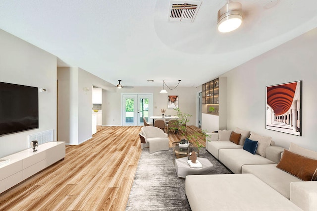 living room featuring french doors, ceiling fan, and hardwood / wood-style flooring