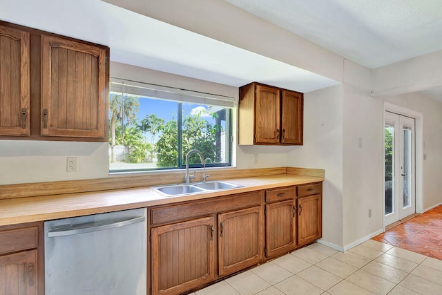 kitchen featuring sink, dishwasher, and light tile patterned floors