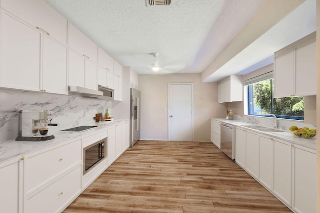 kitchen with light hardwood / wood-style floors, black appliances, sink, and white cabinets