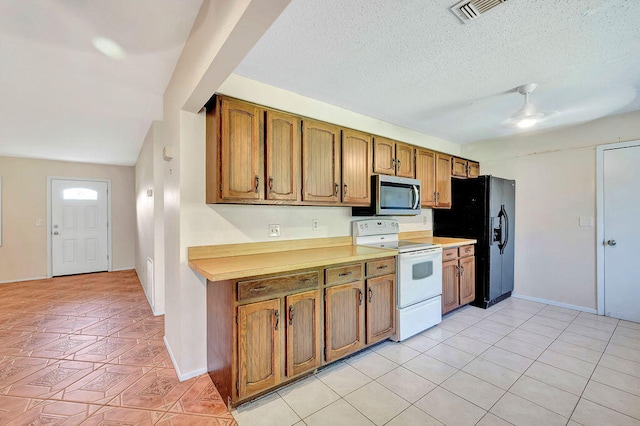 kitchen featuring light tile patterned flooring, vaulted ceiling, white range with electric stovetop, and black fridge with ice dispenser