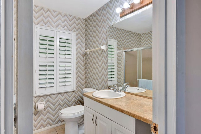 bathroom with vanity, toilet, a shower with shower door, and tile patterned flooring