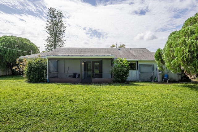 rear view of property with a yard and a sunroom