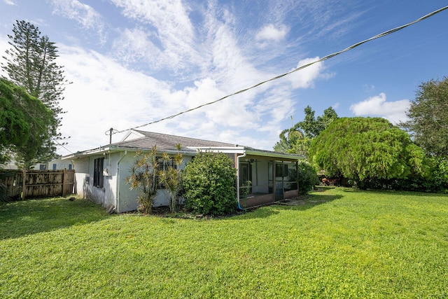 back of house with a lawn and a sunroom