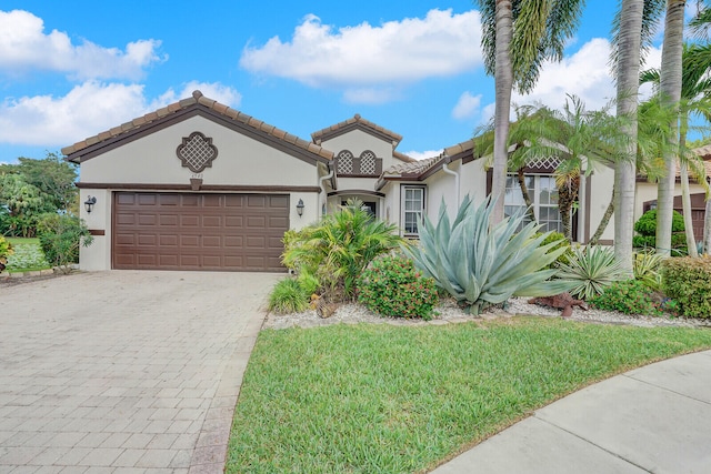 mediterranean / spanish home with a garage and a front yard