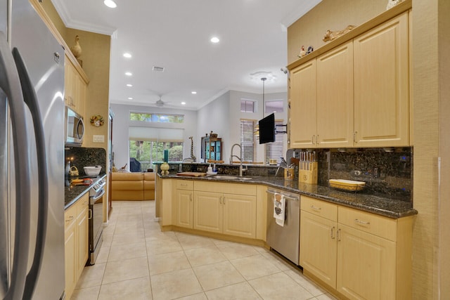 kitchen with dark stone counters, sink, ceiling fan, kitchen peninsula, and stainless steel appliances