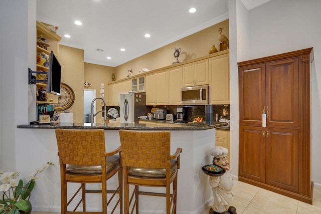 kitchen featuring a breakfast bar, light tile patterned floors, kitchen peninsula, and appliances with stainless steel finishes