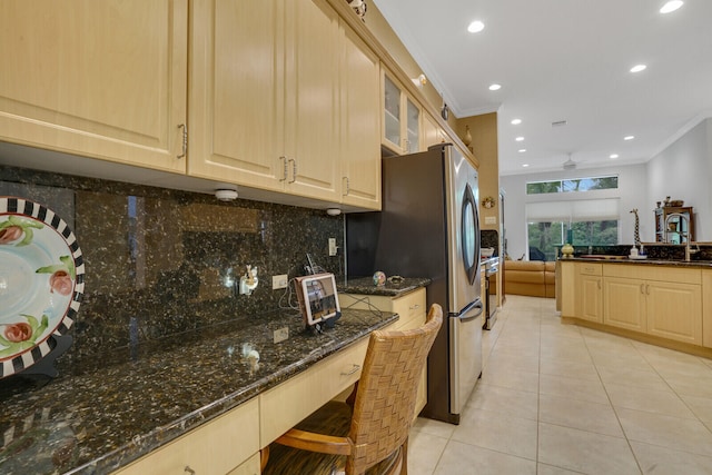 kitchen featuring light brown cabinets, dark stone countertops, ornamental molding, and backsplash