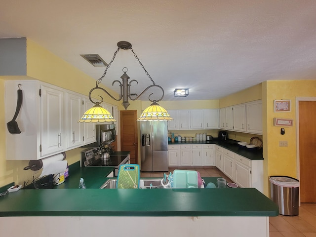 kitchen featuring light tile patterned flooring, stainless steel fridge, kitchen peninsula, decorative light fixtures, and white cabinetry