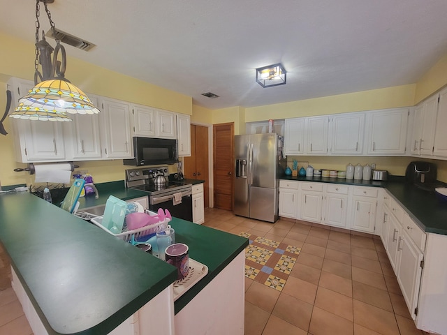 kitchen with electric range oven, white cabinets, light tile patterned floors, and stainless steel fridge