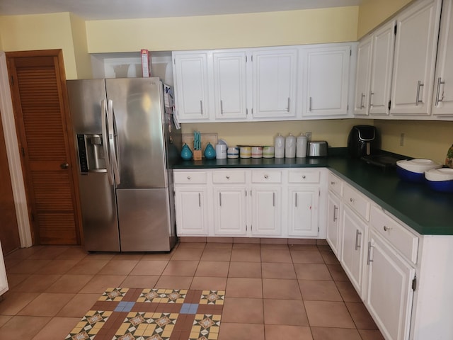 kitchen featuring white cabinets, light tile patterned floors, and stainless steel fridge with ice dispenser