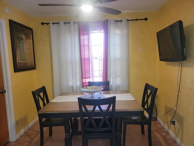 dining room featuring ceiling fan and tile patterned flooring