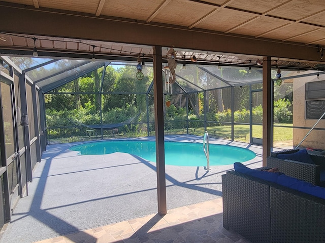 view of swimming pool with glass enclosure and a patio