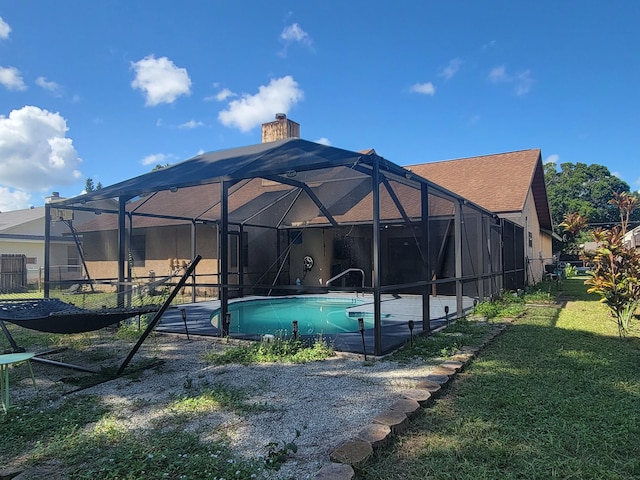 back of house with a lawn and a lanai