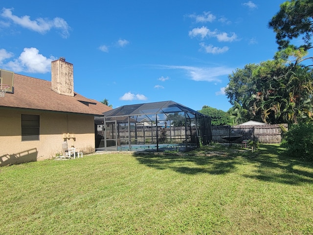 view of yard with a lanai and a fenced in pool