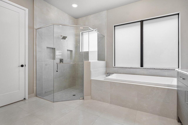 bathroom featuring vanity, independent shower and bath, and tile patterned flooring