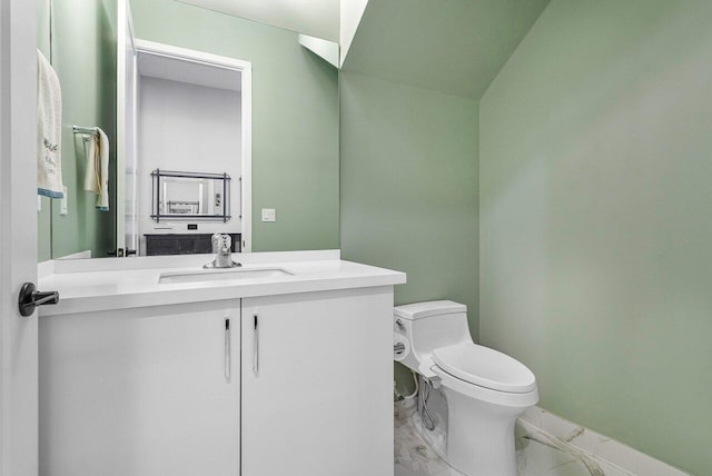 bathroom with vanity, vaulted ceiling, and toilet