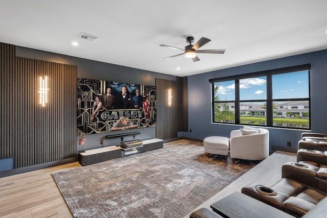 home theater room featuring hardwood / wood-style flooring and ceiling fan