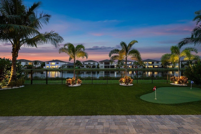 yard at dusk featuring a water view