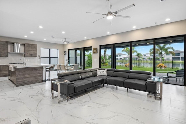 living room with a water view and ceiling fan