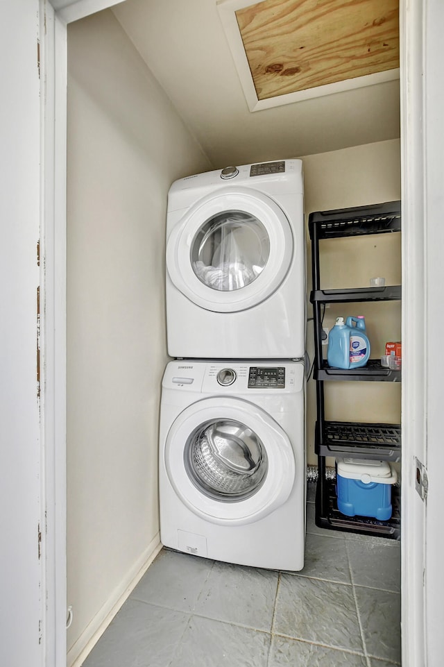 laundry room featuring tile patterned flooring and stacked washer / dryer