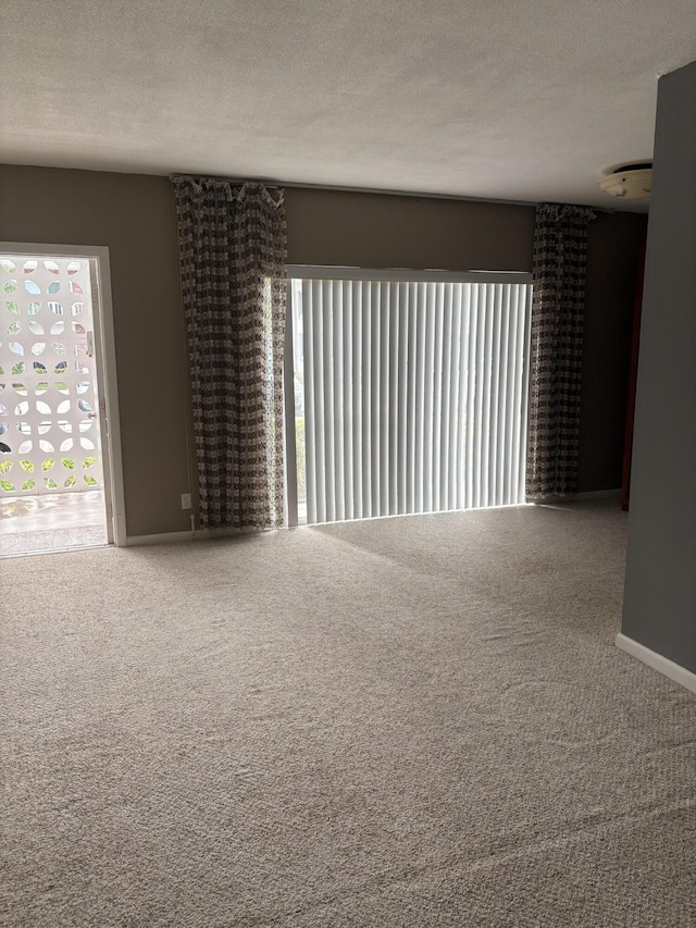 carpeted empty room featuring a textured ceiling