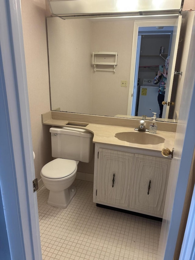 bathroom featuring washer / dryer, tile patterned floors, vanity, and toilet